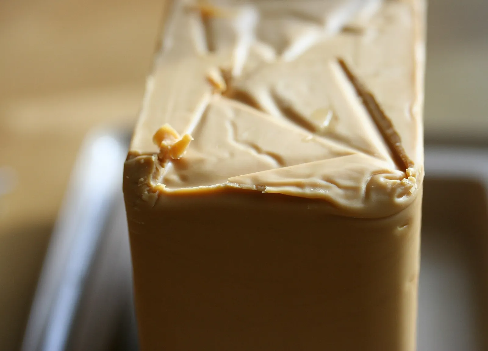 A block of caramel-brown brunost with slicer marks across the top