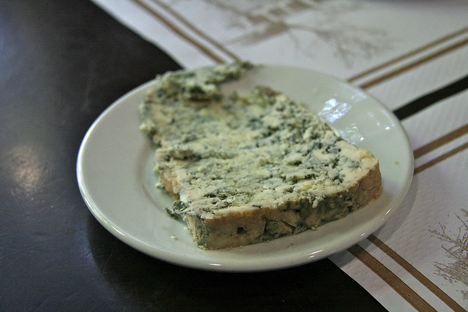 A slab of Cabrales with dense blue-green veining on a white plate