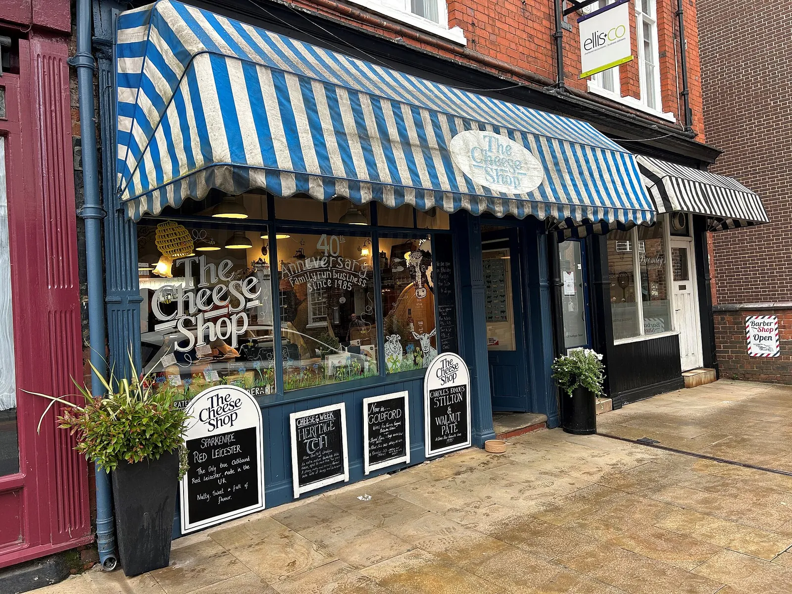 The striped awning and storefront of The Cheese Shop in Chester, England