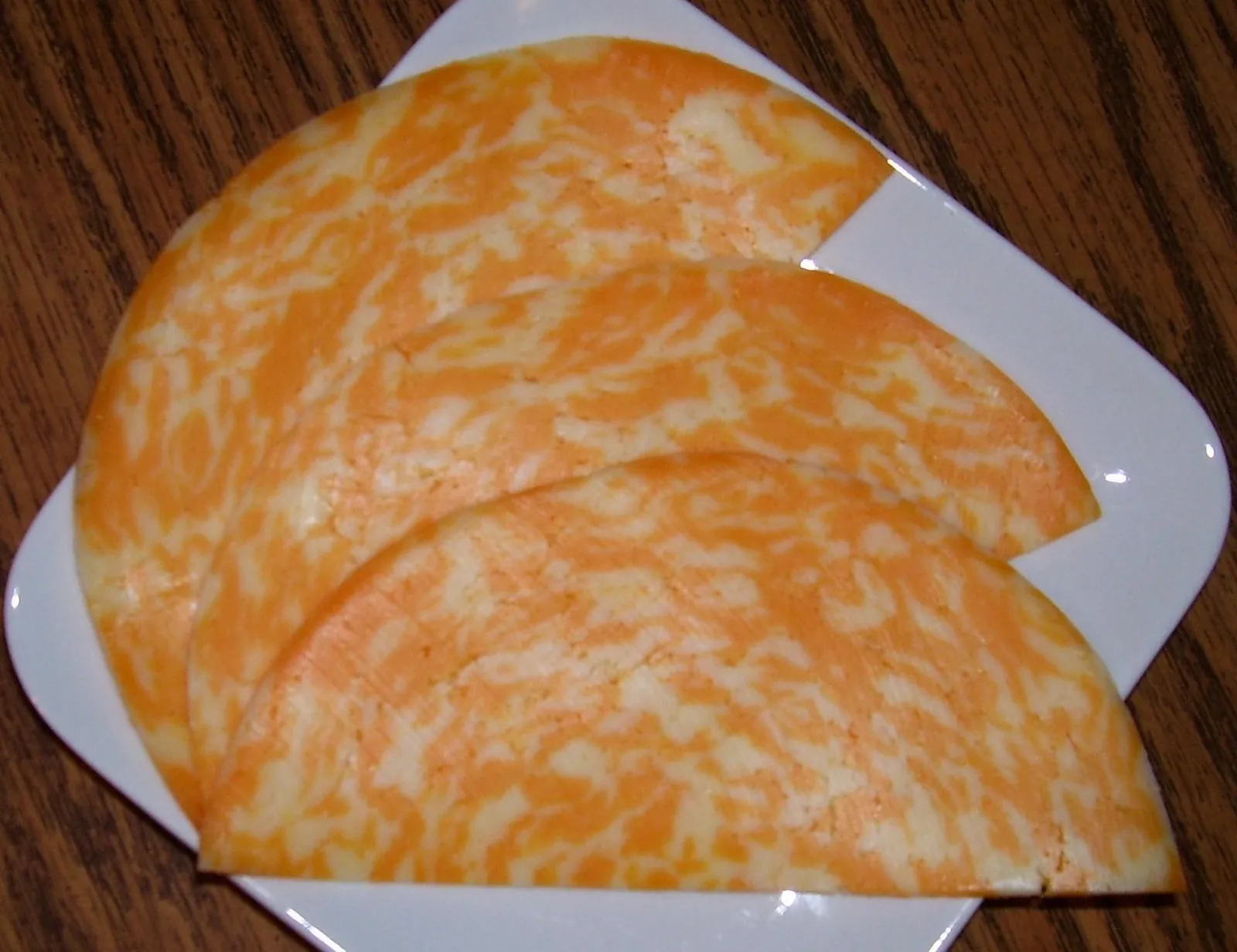 Slices of marbled orange and white Colby Jack on a plate