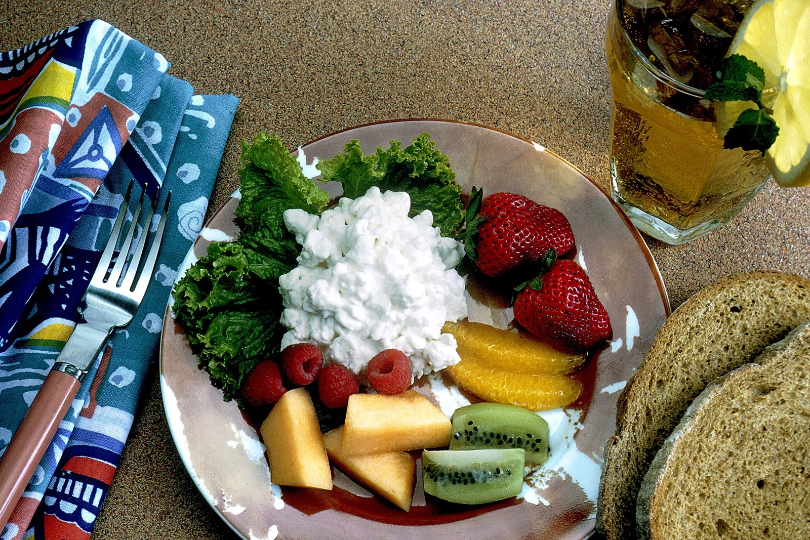Cottage cheese on lettuce with strawberries, kiwi, cantaloupe, orange slices and raspberries