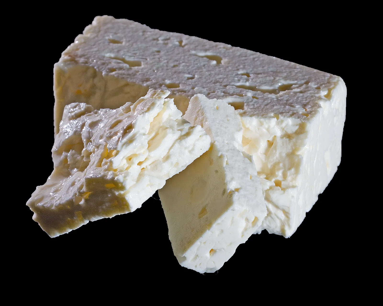A crumbly block of white feta on a black background