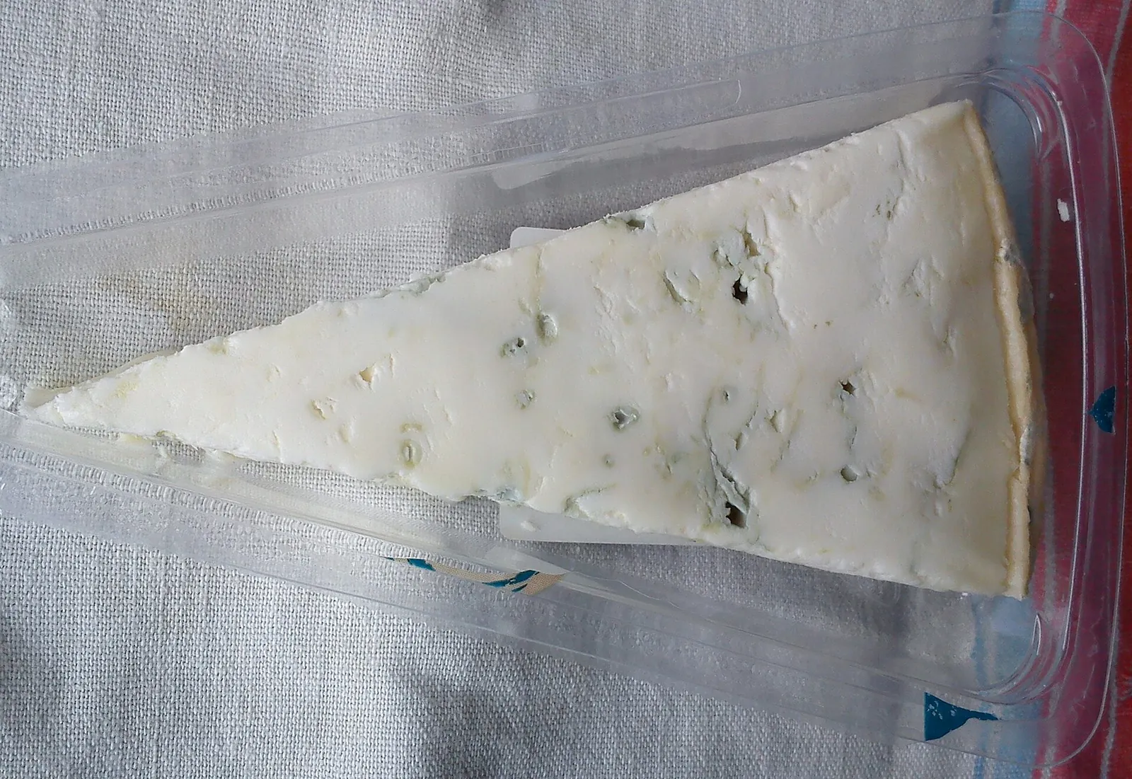 A wedge of Gorgonzola with blue-green veins through its pale paste