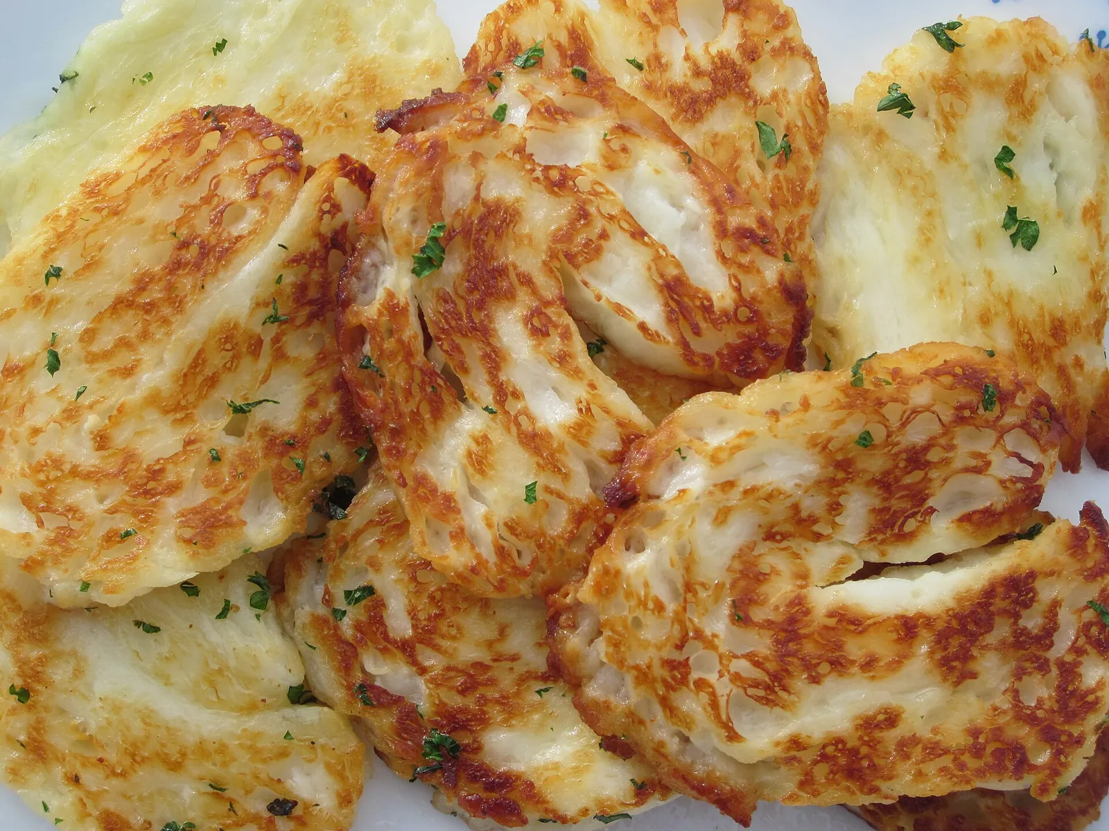Slices of grilled halloumi with golden, charred surfaces piled on a plate