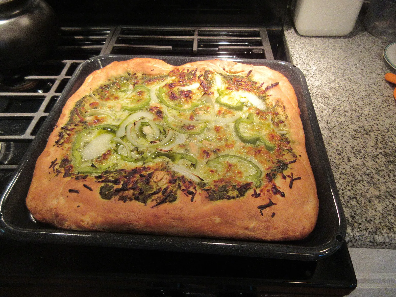 A homemade white pizza with vegetables baked on a sheet pan