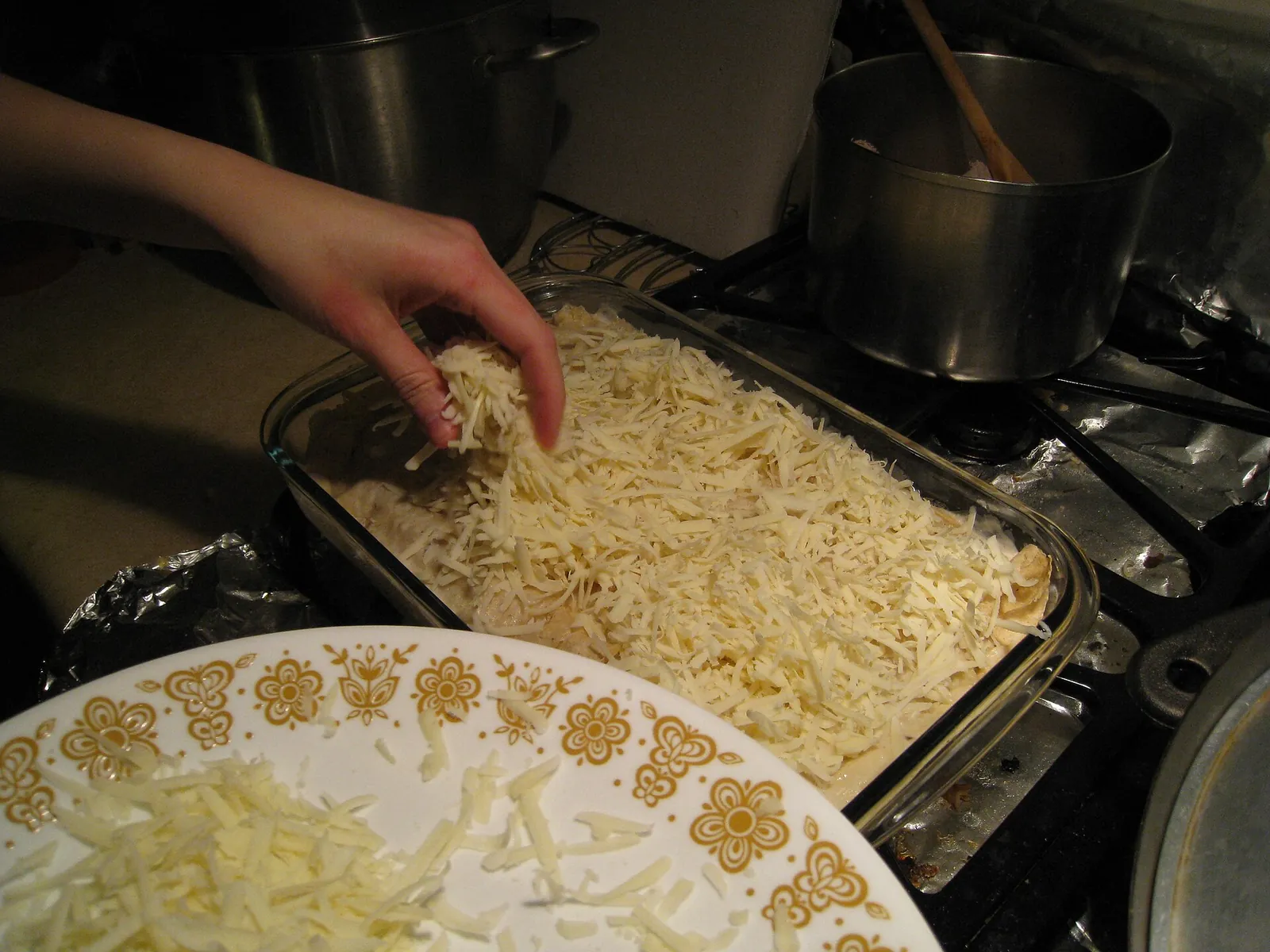 Shredded Monterey Jack being sprinkled over a dish before baking