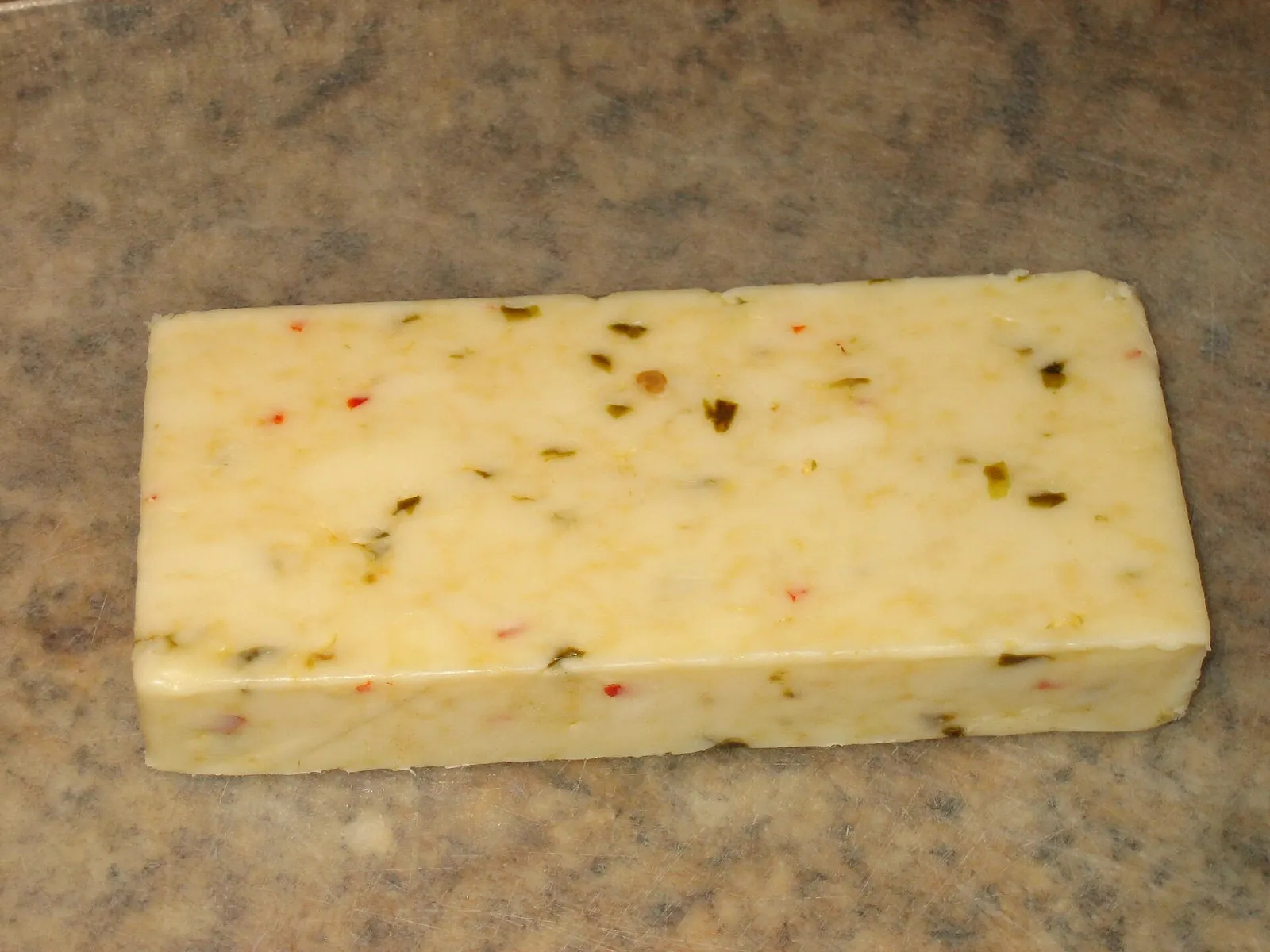A block of pepper Jack flecked with red and green peppers