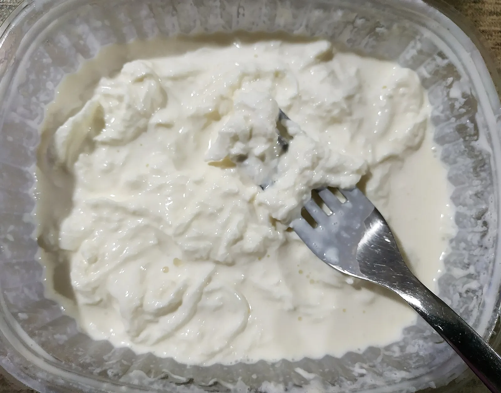 A tub of creamy stracciatella with a fork